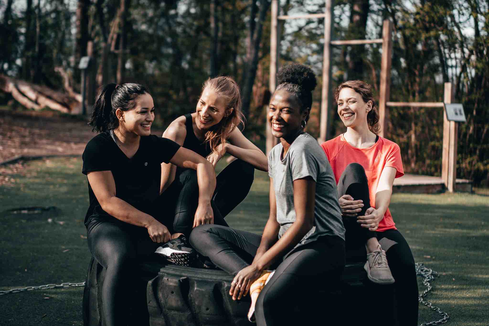 Back view of unrecognizable people performing Padmasana yoga pose on wooden  platform during outdoor training with female instructor in garden stock  photo